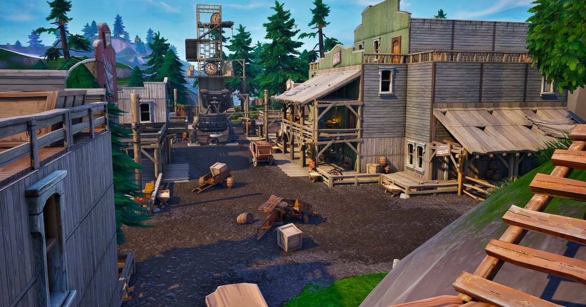 フォートナイトの実際のゲーム画面 — 西部風の木造建築と高い見張り塔が並ぶ町を見下ろす場面