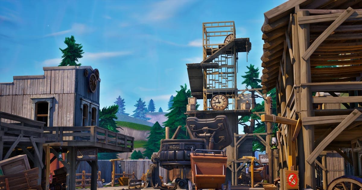Actual Fortnite gameplay — a Western-style town of wooden buildings and a clock tower under a blue sky