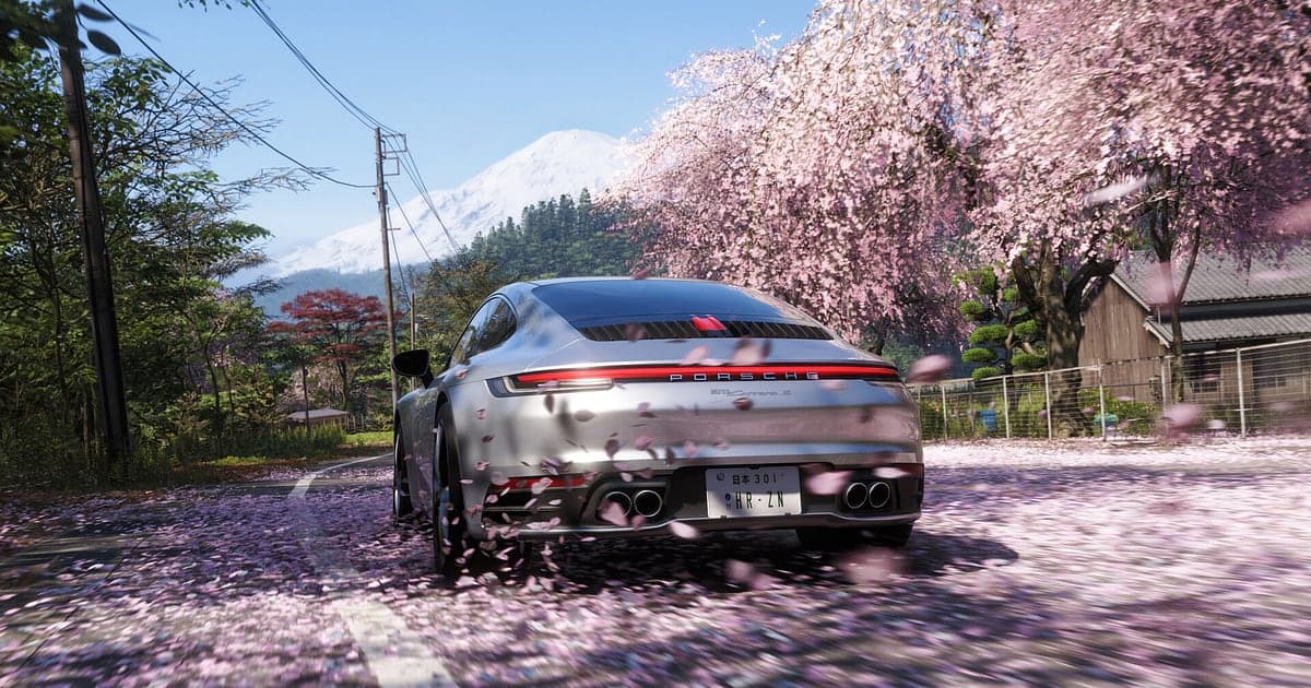 Mobil sport perak Forza Horizon 6 melaju di jalan pedesaan Jepang yang tertutup kelopak sakura, dengan Gunung Fuji bersalju di kejauhan