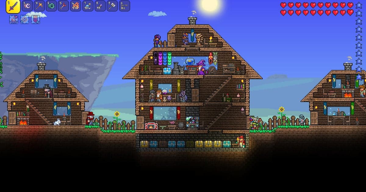 Eine Stadt in Terraria an einem sonnigen Tag mit einem dreistöckigen Holzhaus und zwei kleineren Häusern voller NPCs