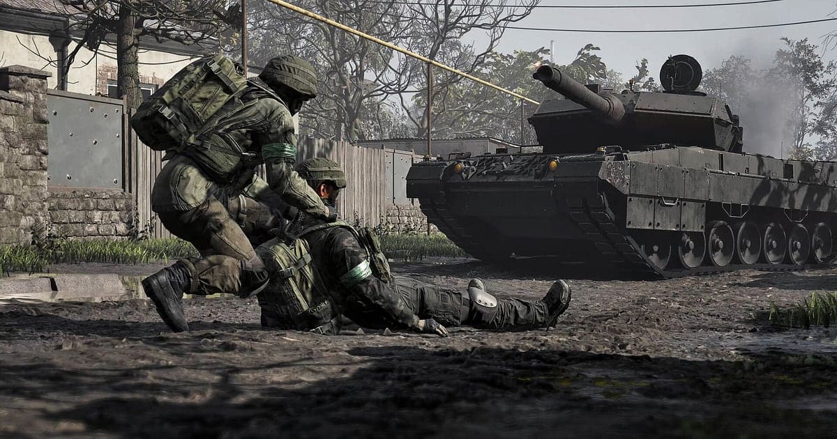 Ein Soldat zieht in WARDOGS einen verwundeten Squadkameraden in Deckung, während ein Panzer eine Straße in der Stadt entlangrollt