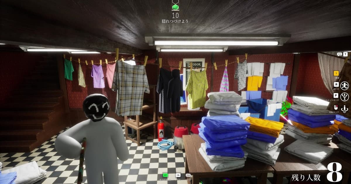 Captura oficial de MECCHA CHAMELEON en Steam: en una lavandería de sótano con tendederos y pilas de toallas, un personaje blanco con la cabeza pintada de negro, con ojos blancos y una sonrisa dibujada encima, sostiene una brocha