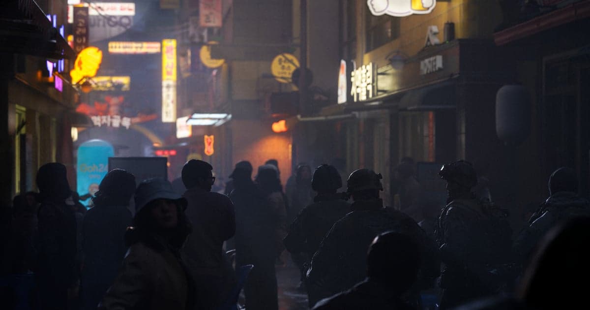 한글 네온 간판이 늘어선 밤 골목에서 연기와 인파를 헤치고 전진하는 병사들을 담은 콜 오브 듀티: 모던 워페어 4 공식 스크린샷