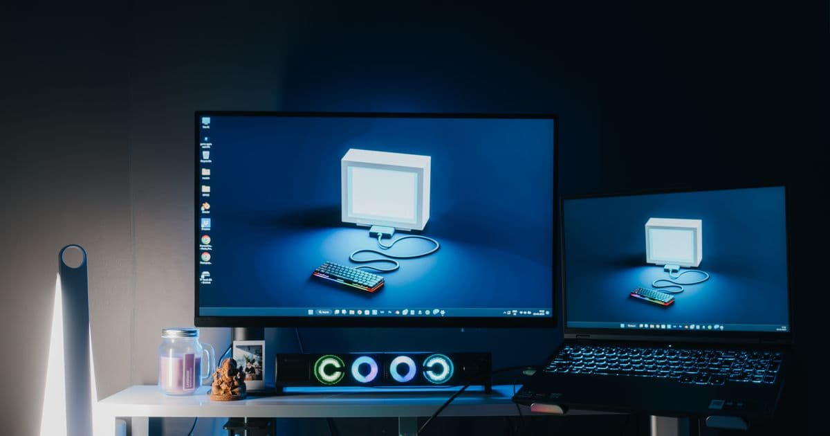 A desk with dual monitors and a keyboard