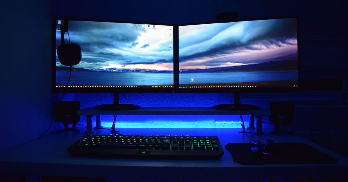 A desk with two monitors and a keyboard